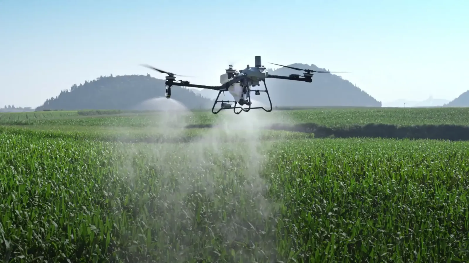 Drone agricolo in volo sopra un campo coltivato mentre irrora le colture